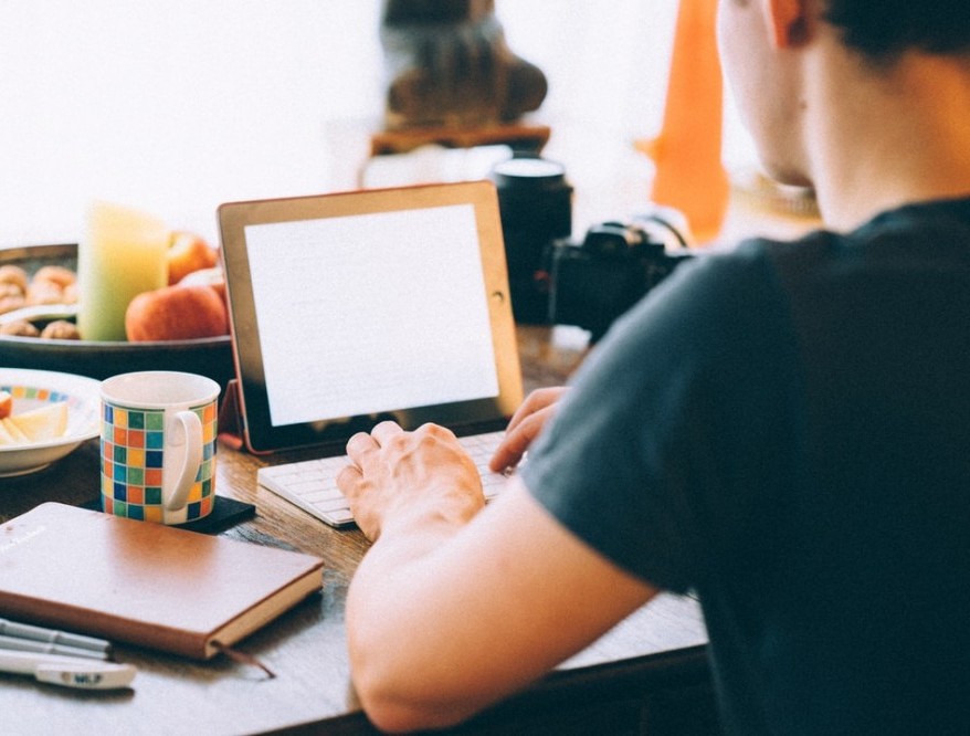 man writing on a computer